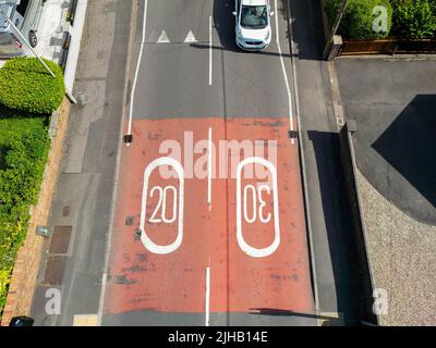 Pontypridd, Wales - Juli 2022: Luftaufnahme von Straßenmarkierungen, die Geschwindigkeitsbegrenzungen von 20 mph und 30 mph auf einer Landstraße in der Nähe eines Wohngebiets zeigen. Stockfoto