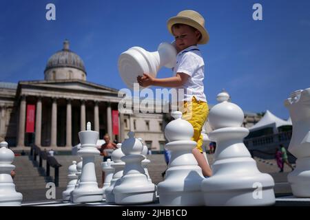 Ein kleiner Junge nimmt am ChessFest, der größten eintägigen Schachveranstaltung Großbritanniens, am Trafalgar Square im Zentrum von London Teil. Bilddatum: Sonntag, 17. Juli 2022. Stockfoto