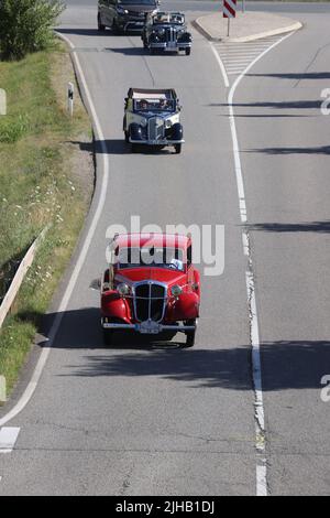 Reinsdorf, Deutschland. 17.. Juli 2022. Ein Hansa Borgward 1100, Baujahr 1936, und andere Oldtimer fahren auf einer Straße während der Oldtimer-Fahrt „August Horch Klassik“ von 10.. Es werden 135 Oldtimer und 30 Oldtimer erwartet. Kredit: Bodo Schackow/dpa/Alamy Live Nachrichten Stockfoto