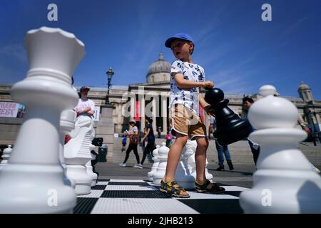 Finn Moriarty, 5 Jahre alt, bewegt riesige Schachfiguren während des ChessFest, dem größten eintägigen Schachereignis Großbritanniens, am Trafalgar Square im Zentrum von London. Bilddatum: Sonntag, 17. Juli 2022. Stockfoto