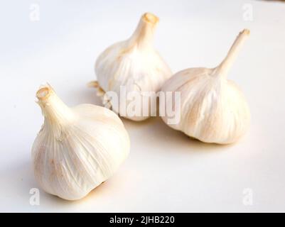 Knoblauchköpfe und Nelken auf weißem Hintergrund Stockfoto