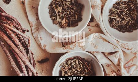 Kleine Schüsseln mit getrocknetem, heilendem grünem Tee und Kräutern, ritueller Reinigung und Reinigung, Nahaufnahme Stockfoto