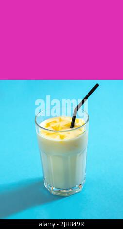 Konzeptioneller Rahmen. Ein Getränk in Neon. Milchmilchshake Lassi auf Neon-Hintergrund Stockfoto