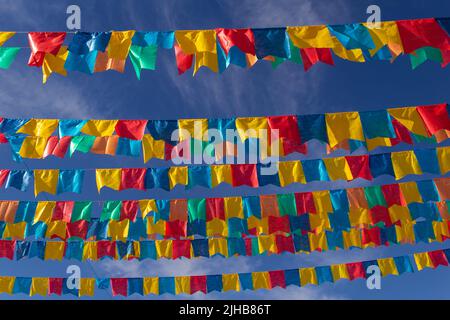 Goiania, Goiás, Brasilien – 17. Juli 2022: Mehrere Wäscheleinen mit Stofffahnen gegen den blauen Himmel für die juniparty - typisch brasilianische 'Quadrilha' Stockfoto