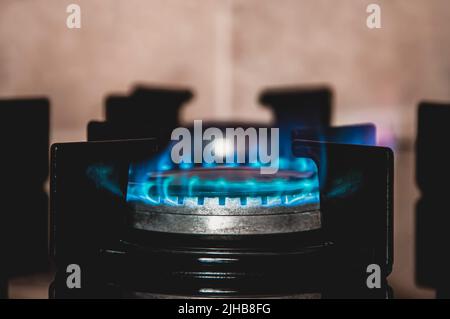 Nahaufnahme des blauen Feuers vom Herd der heimischen Küche. Gasherd mit brennenden Flammen. Industrielle Ressourcen und Wirtschaft Konzept.Quelle des Feuers Stockfoto