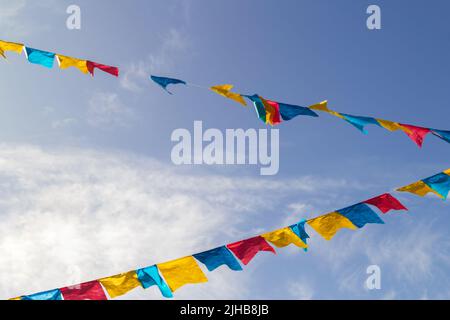 Goiania, Goiás, Brasilien – 17. Juli 2022: Einige Wäscheleinen mit Stoffwinseln gegen den blauen Himmel für die Juni-Party - typisch brasilianische Party. Stockfoto