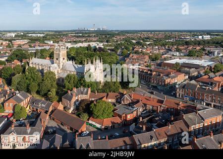 SELBY ABBEY, GROSSBRITANNIEN - 20. JUNI 2022. Luftaufnahme der Skyline von Selby Abbey mit dem Drax Power Station in der Ferne Stockfoto