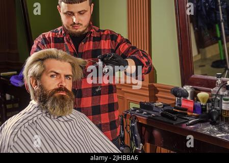 Zuversichtlich in seiner Wahl. Hipster mit gefärbtem Bart und Schnurrbart. Mann wollen neue Frisur. Männliche Schönheit und Mode. Reifer Mann im Friseurladen. Brutal Stockfoto