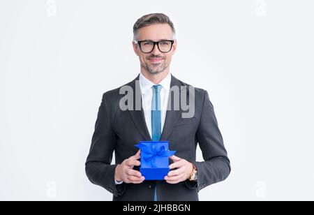 Glücklich reifen Mann in Brillen und Anzug halten Geschenk-Box auf weißem Hintergrund isoliert Stockfoto