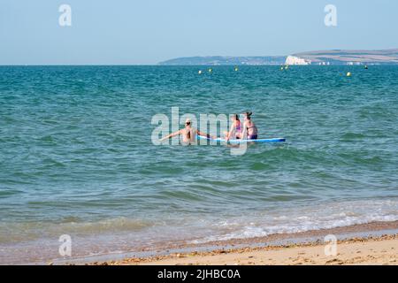 Boscombe Beach, Bournemouth, Dorset, England, Großbritannien, 17.. Juli 2022, Wetter. Über die Südküste zieht eine rekordverdächtige Hitzewelle ein, und vom Met Office wird eine bernsteinfarbene Warnung vor Hitze ausgegeben. Paddlebarder haben Spaß in der Sonne. Kredit: Paul Biggins/Alamy Live Nachrichten Stockfoto