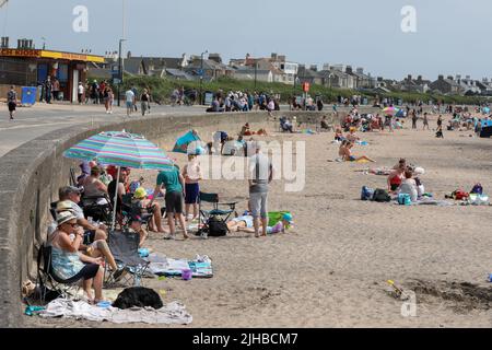 Troon, Großbritannien. 17.. Juli 2022. Da die Wetterprognosen Temperaturen von über 30C prognostizierten, strömten Touristen und Einheimische nach Troon South Beach, um das Sommerwetter zu nutzen. Kredit: Findlay/Alamy Live Nachrichten Stockfoto