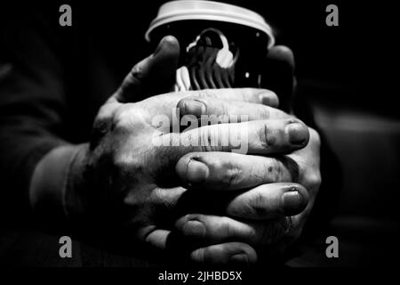 Hart arbeitende Hände halten Eine Tasse Kaffee Stockfoto