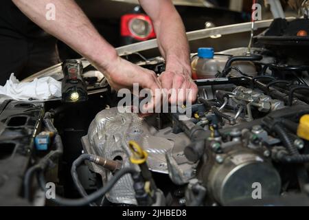 Nahaufnahme der Automechaniker Hände tun Auto-Service und Wartung. Stockfoto