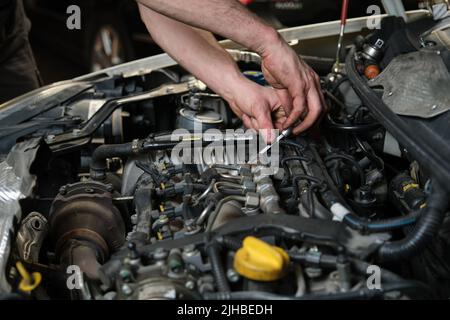 Nahaufnahme der Automechaniker Hände tun Auto-Service und Wartung. Stockfoto