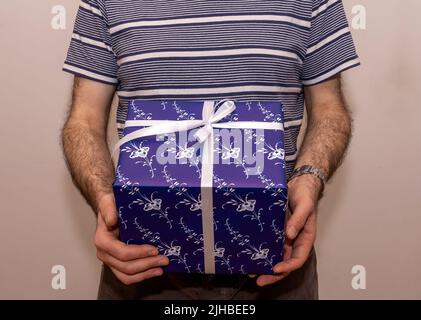 Mann hält Geschenkkarton Paket in seinen Händen Stockfoto