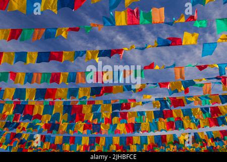 Goiania, Goiás, Brasilien – 17. Juli 2022: Mehrere Wäscheleinen mit Stofffahnen gegen den blauen Himmel für die juniparty - typisch brasilianische 'Quadrilha' Stockfoto