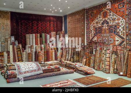 Auswahl an wunderschönen orientalischen Teppichen im traditionellen Teppichladen Stockfoto