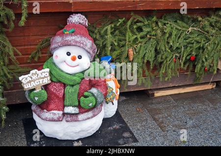 Eine Figur eines Schneemanns in einem Hut, der an einem Wintertag auf einem Weihnachtsmarkt steht Stockfoto