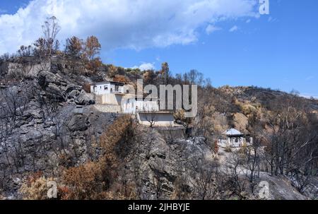 Feuer beschädigte Häuser, verursacht durch einen wilden Brand auf einem Hügel in Koroni, Messinia, an der Südspitze des Peloponnes, Griechenland. Stockfoto