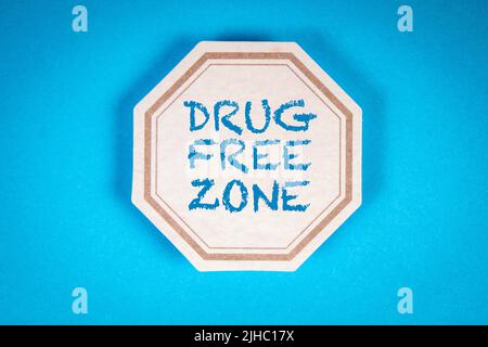 Drogenfreie Zone. Text auf einem dekorativen Etikettenblatt.Blauer Hintergrund. Stockfoto