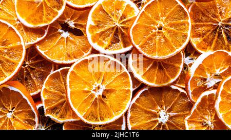 Getrocknetes Orange. Getrocknete orangefarbene Scheiben Hintergrund. High-Angle-Ansicht. Draufsicht auf die Textur von Zitrusfrüchten aus der Nähe. Stockfoto