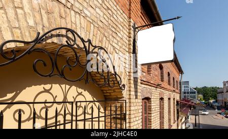 Quadratisches Schild am alten Backsteingebäude der Stadt. Tafel zur Anzeige von Café, Restaurant, Geschäft, Museum, Hotel, Firmenname oder -Logo. Poster für Außenwerbung. Hochwertige Fotos Stockfoto