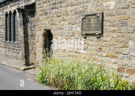 Bolsterstone, South Yorkshire, Großbritannien Juni 25 2022 die Porter's Lodge aus dem 19.. Jahrhundert mit einer Ausstellung von gelben Blumen, die entlang der Steinmauer laufen. Stockfoto