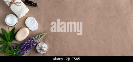 Natürliche Bio-Kosmetik und Lupine Blumen auf Bastelpapier Hintergrund. Feuchtigkeitsspendende Creme, Seife und Handtuch. Körperpflegekonzept. Spa und Schönheitsbehandlungen Stockfoto