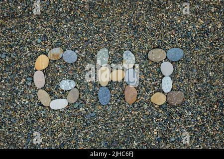 Buchstaben g h habe ich aus Steinen im Sand am Strand gemacht Stockfoto