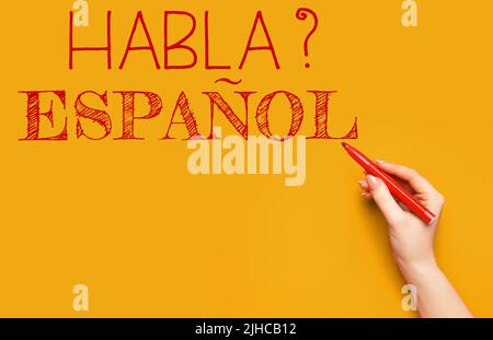 Handschriftentext HABLA ESPANOL? (SPRECHEN SIE SPANISCH?) Auf orangefarbenem Hintergrund Stockfoto