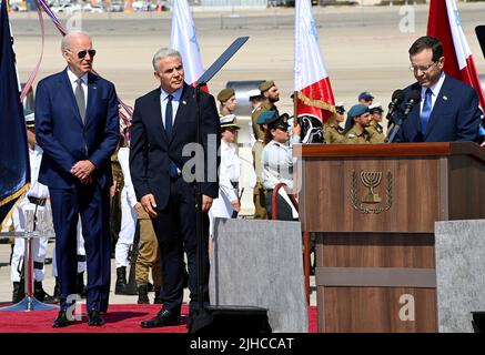 Tel Aviv, Israel. 13. Juli 2022. Der israelische Präsident Isaac Herzog, rechts, begrüßt US-Präsident Joe Biden, links, während der israelische Premierminister Yair Lapid, Mitte, während der Ankunftszeremonien am Flughafen Ben Gurion am 13. Juli 2022 in Tel Aviv, Israel, zuschaut. Stockfoto