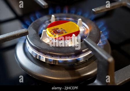 Gas Import und Export Konzept. Ein brennender Gasbrenner eines Heizofens, in dessen Mitte eine Flagge abgebildet ist - Spanien Stockfoto