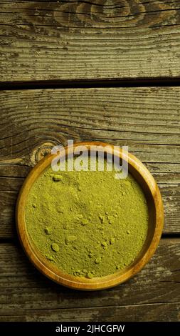 Moringa Pulver Superfood sehr gesunde Pflanze in Holzschale auf Holztisch Draufsicht Gewürze und Nahrungsergänzungsmittel Gesunder Lebensstil Stockfoto