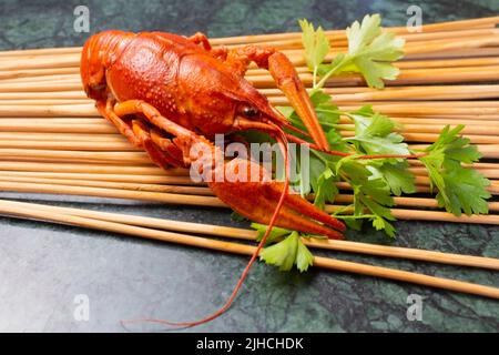 Frisch gekochte rote Krebse auf einem Holzständer mit Petersilie. Toller Snack für Bier. Stockfoto