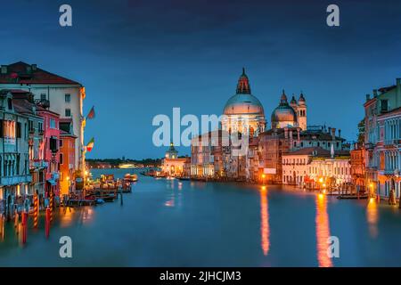 Der Canal Grande in Venedig, Italien mit der berühmten Basilika Santa Maria della Salute im Hintergrund während der „Blauen Stunde“ Stockfoto