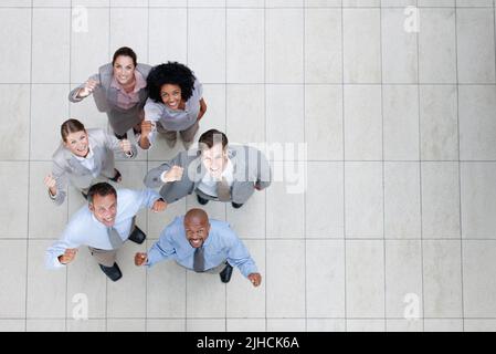 Der einzige Weg ist mit diesem Team. Draufsicht auf ein triumnendes Geschäftsteam, das Sie anschaut - Copyspace. Stockfoto