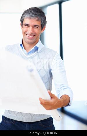 Glücklicher Geschäftsmann mit Blaupause. Porträt eines lächelnden, reifen männlichen Architekten, der die Blaupause überprüft. Stockfoto