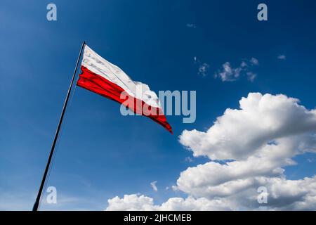 Die rot-weiße Flagge Polens flattert im Wind Stockfoto