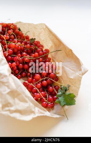 Draufsicht auf rote Johannisbeerbeeren in Papiertüte. Sommer gesunde Ernte Nahrung Stockfoto
