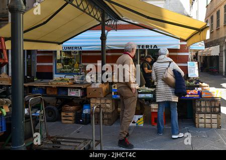 Ein Seniorenpaar kauft an einem Obst- und Gemüsestand auf dem Straßenmarkt auf der Piazza Venezia, dem historischen Zentrum von Rapallo, Genua, Ligurien, Italien Stockfoto