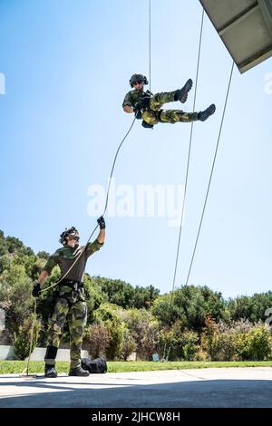 Schwedische Marineinfanteristen mit 4. Marine-Regiment, schwedisches Amphibienkorps rappeln während der Übung TYR 22 im NATO Maritime Interdiction Operational Training Center (NMIOTC) in Souda Bay, Griechenland, 11. Juli 2022 von einem Turm ab. TYR 22 ist eine am NMIOTC stattfindende Übung für maritime Interdiktionsoperationen, bei der schwedische Marineinfanteristen, US-Marineinfanteristen und Kampfkommandidaten der US-Marine zusammengebracht werden, um die operativen Kapazitäten, Fähigkeiten und Interoperabilität der US- und NATO-Partner zu verbessern. (USA Marine Corps Foto von Sgt. William Chockey) Stockfoto