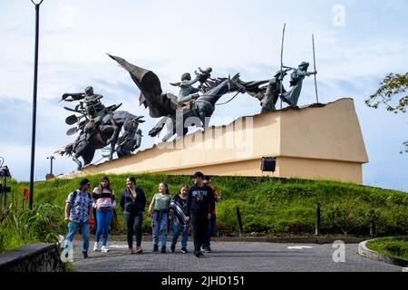 MANIZALES, KOLUMBIEN - MAI 2022: Touristen am Monument für die Kolonisatoren, das der Künstler Luis Guillermo Vallejo mit dem Sandbronzeguss geschaffen hat Stockfoto