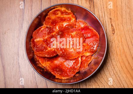 Rohes Schweinefleisch auf dem Teller, koreanisches traditionelles Schweinebauch-BBQ, japanisches Fleisch, Hot Pot oder Shabu im Restaurant, Grillgerichte Stockfoto