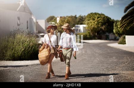 Ein liebevolles junges Paar, das durch ein Wohngebiet läuft. Stockfoto
