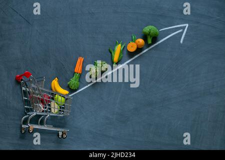 Gemüse und Obst Preis erhöhen.Gemüse und Obst und Pfeile auf Kreidetafel Hintergrund.Lebensmittelpreise. Stockfoto