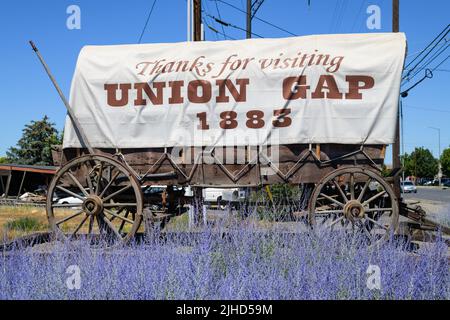 Union Gap, WA, USA - 11. Juli 2022; Traktioneller Planwagen mit Text, der bedankt sich für den Besuch von Union Gap mit blauen Blumen im Vordergrund Stockfoto