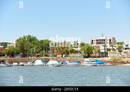 30. Dez 2021, Colon, Entre Rios, Argentinien: Hafen der Stadt mit angedockten Schiffen, von einem Boot auf dem Uruguay-Fluss aus gesehen. Stockfoto