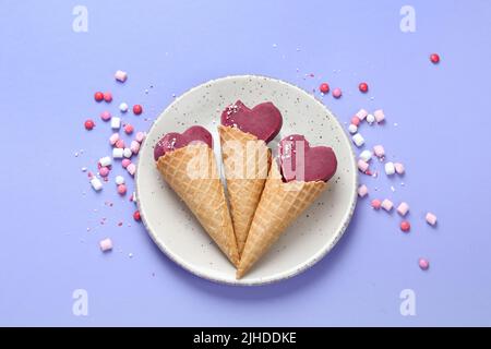 Violettes Heidelbeer-Eis auf lilafarbenem Hintergrund. Stimmungsvolles, süßes Menükonzept. Draufsicht, flach liegend Stockfoto