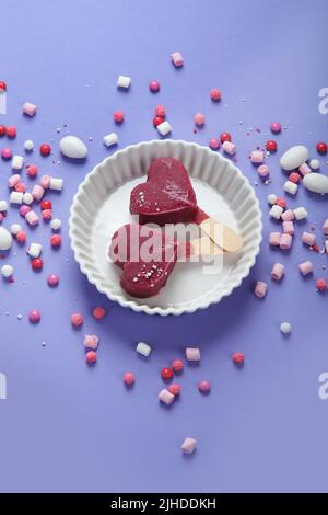 Violettes Heidelbeer-Eis auf lilafarbenem Hintergrund. Stimmungsvolles, süßes Menükonzept. Draufsicht, flach liegend, Kopierbereich Stockfoto