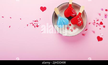 Verschiedene Arten von Eis aus dem Eisbein auf rosa Hintergrund. Stimmungsvolles Sommerkonzept. Draufsicht, flach liegend, Kopierbereich Stockfoto